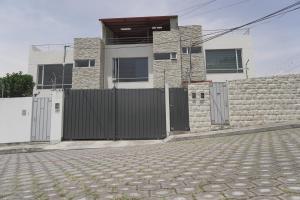 a house with a gate and a stone wall at Casa Calma in Quito