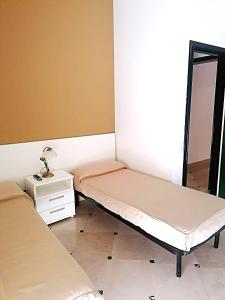 a small room with two beds and a mirror at Hyencos Hotel Calos in Torre San Giovanni Ugento
