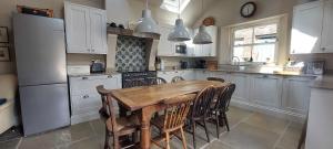 a kitchen with a wooden table and a refrigerator at School House in Reeth