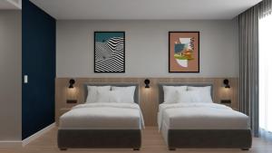 a bedroom with two beds and two paintings on the wall at Spark By Hilton Van City Centre in Van +4 photos