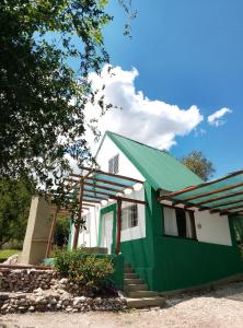 a green and white house with a green roof at CABAÑAS L y L in Villa Santa Cruz del Lago