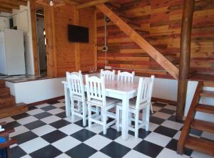 a dining room with a white table and chairs at CABAÑAS L y L in Villa Santa Cruz del Lago