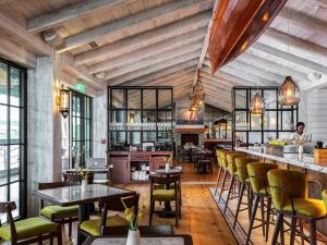 a restaurant with tables and chairs and a bar at Delamar Mystic in Mystic