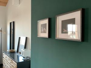 a room with a green wall with two pictures on it at Chalet Nest in Gravedona