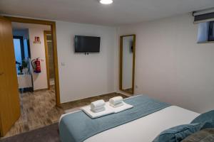 a bedroom with a bed and a tv on the wall at Casa da Eira Campia in Vouzela