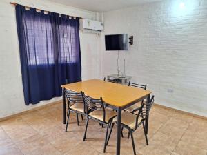 a wooden table and chairs in a room with a tv at Mercedario Aparts in Barreal