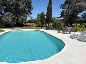 a swimming pool with lounge chairs next to at La Pulperia in Capilla del Señor
