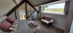 a bedroom with a bed and a window and a chair at School House in Reeth
