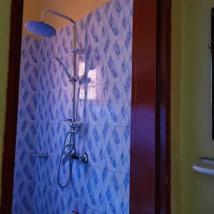 eine Dusche in einem Badezimmer mit einer blau gefliesten Wand in der Unterkunft Maison Altra in Bobo-Dioulasso
