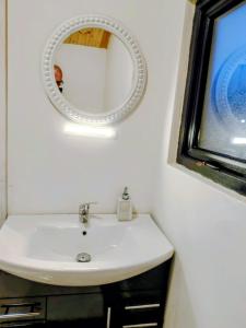 a bathroom with a white sink and a mirror at Sky View Cabin in Ardaghy