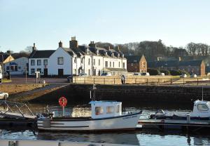 a boat is docked at a dock in the water at The Royal Hotel Cromarty in Cromarty