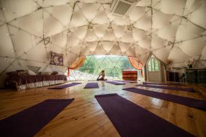 a woman is sitting in a room with purple mats at Бунгала Дара in Kalofer