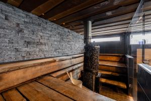 a bar with wooden walls and a brick wall at Villa West Ellivuori - High Quality 6BR Villa with Jacuzzi in Sastamala