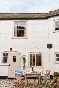 a white house with a table and chairs in front of it at Courtyard Cottages Lymington, 2 Adults only in Lymington