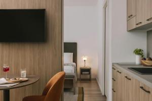 a kitchen with a table and a television on a wall at Numa Milan Montenero in Milan +33 photos