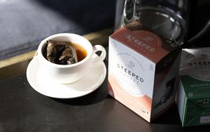 a cup of coffee and a box on a table at Kasa Altmayer Savannah in Savannah