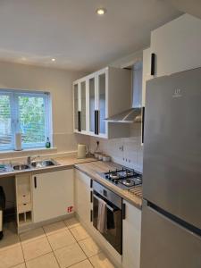 a kitchen with white cabinets and a stainless steel refrigerator at 4 School Path in Ironbridge