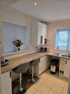 a kitchen with white cabinets and a wooden counter top at 4 School Path in Ironbridge +11 photos