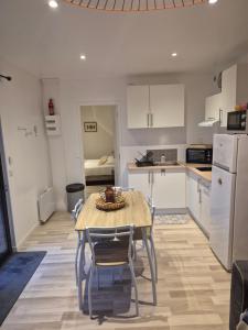 a kitchen and dining room with a table and chairs at Le Colibri in Le Port-des-Barques
