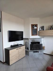 a living room with a fireplace and a flat screen tv at Easy Albese Comfort in Albese Con Cassano