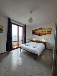 a bedroom with a large bed and a large window at Easy Albese Comfort in Albese Con Cassano