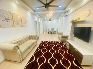 a living room with a couch and a flat screen tv at HomestayBondaFaiiha in Port Dickson