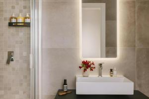 a bathroom with a white sink and a mirror at Numa Milan Montenero in Milan