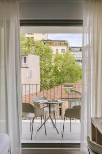 a room with a balcony with a table and chairs at Numa Milan Montenero in Milan