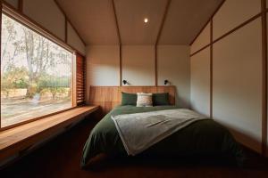a bedroom with a bed and a large window at Ellas Rest in Torquay