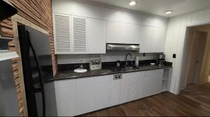 a kitchen with white cabinets and a black refrigerator at oak&stone in Dalton +30 photos