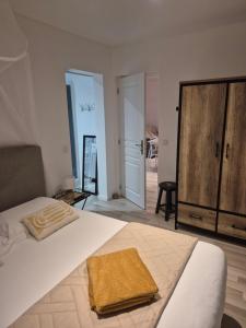 a bedroom with a large bed and a wooden cabinet at Le Colibri in Le Port-des-Barques