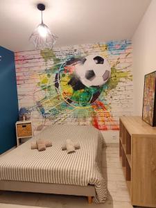 a bedroom with a soccer ball mural on the wall at Villa L'Echappée Oléronaise in Saint-Georges-dʼOléron +31 photos