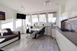 a kitchen and living room with a table and a couch at LC pokoje & apartamenty B52 in Szczecin