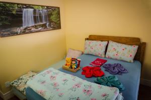 a bedroom with a bed with pillows and a beduteneway at Quarto Aconchegante Teresópolis Refúgio Cristão in Teresópolis
