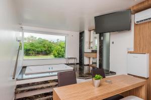 a living room with a table and a large window at Rainbow Motel (Adult Only) in Itupeva