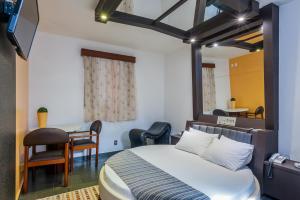 1 dormitorio con 1 cama, mesa y sillas en Rainbow Motel (Adult Only) en Itupeva