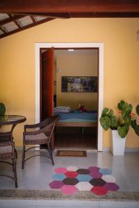 a room with a bed and a table and a rug at Quarto Aconchegante Teresópolis Refúgio Cristão in Teresópolis