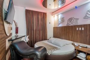 a room with a bed and a desk and a television at Rainbow Motel (Adult Only) in Itupeva