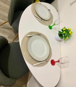 a white table with two plates and two chairs at Lemon Luxury Studio in Xanthi +3 photos