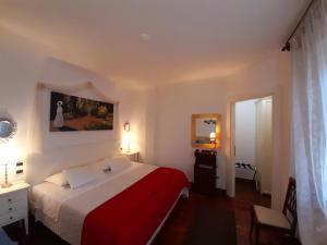 a bedroom with a red and white bed and a mirror at Luxury House B&B in Bassano del Grappa