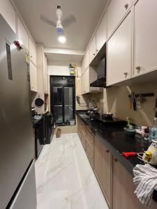 a kitchen with white cabinets and black counter tops at Sumeru in Mumbai