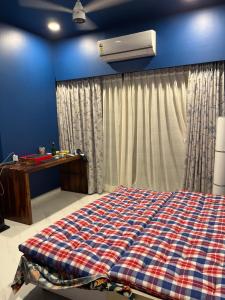 a bedroom with a bed and a air conditioner at Sumeru in Mumbai