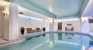 a swimming pool in a hotel with chairs around it at Saint John Harbourfront Hotel in Saint John