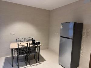 a kitchen with a table and a refrigerator at Milano Hotel in Al-ʿUla +50 photos