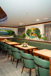 a restaurant with wooden tables and green chairs at Hotel Sarovaras Legacy in Bangalore +25 photos