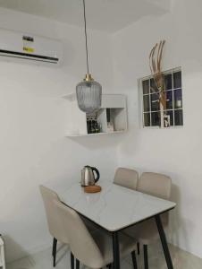 a white table with chairs and a tea kettle on it at Modern 2 Storey 2BR Home with 2 Parking Space in Manila