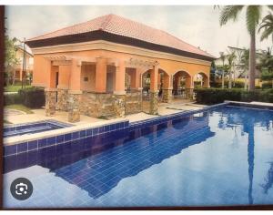 a house with a swimming pool in front of a building at Modern 2 Storey 2BR Home with 2 Parking Space in Manila