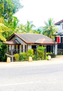 a house with a fence in front of a street at D2 Holiday Inn in Badulla