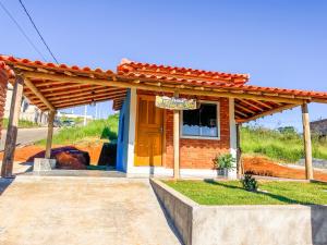 a small brick house with a sign on it at Chalé Flor de Ypê in Carrancas