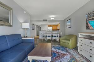 a living room with a blue couch and a table at Seas the View at Ocean Reef Resort #320 in Myrtle Beach